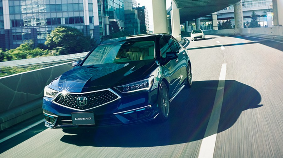 A dark-blue 2021 Honda Legend Hybrid EX with Honda Sensing Elite drives on a Japanese roadway