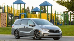 A silver 2021 Honda Odyssey minivan parked outside a colorful playground