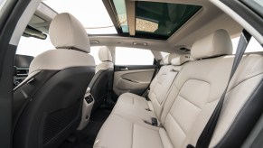 A view of the 2021 Hyundai Tucson compact crossover SUV's white-leather seating and panoramic sunroof