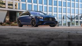 A blue 2021 Mercedes-AMG E63 S Wagon parked on a building's roof in a city