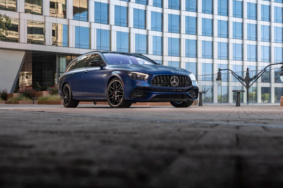 A blue 2021 Mercedes-AMG E63 S Wagon parked on a building's roof in a city