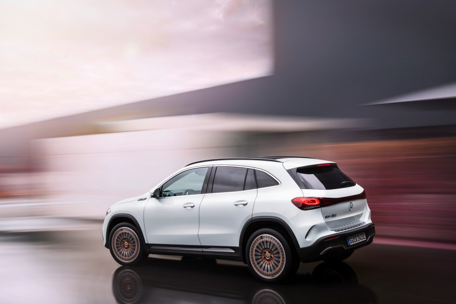 Computer rendering of a white 2021 Mercedes-Benz EQA250 electric crossover SUV with a blurred gray and brown background