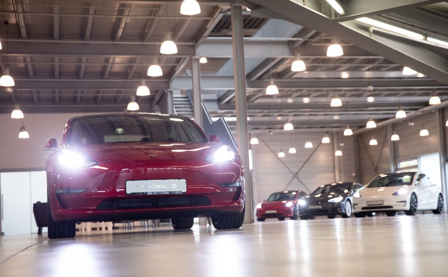 A red Tesla Model 3 EV and other models at the Tesla Service Center in Hamburg, Germany, on October 21, 2020