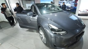 Customers look at the first Tesla Model Y electric SUV arriving at a Tesla store in Hangzhou, Zhejiang Province, China, on January. 4, 2021