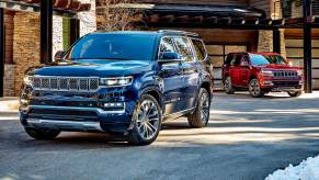 The 2022 Jeep Grand Wagoneer Obsidian trim near a red Jeep Grand Wagoneer