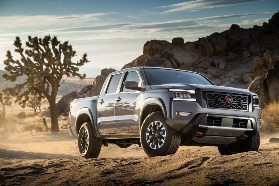 A silver 2022 Nissan Frontier driving on a dirt road