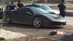 An image of a yellow Ferrari 488 on the side of the road painted black.