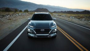 the 2021 hyundai kona in thundra gray driving down an open road in the desert