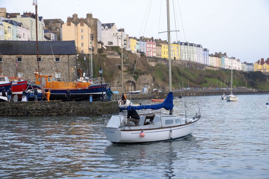 A yacht owner tries to start the engine in Tenby Harbour where Pleasure and Working boats are being returned to the sea on Spring High Water