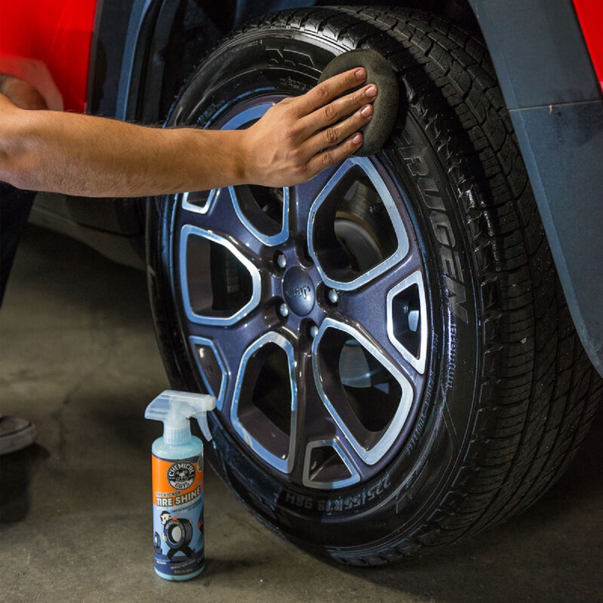 A worker applies Chemical Guys Tire Kicker tire shine