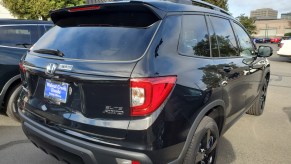 A black Honda Passport seen from the side