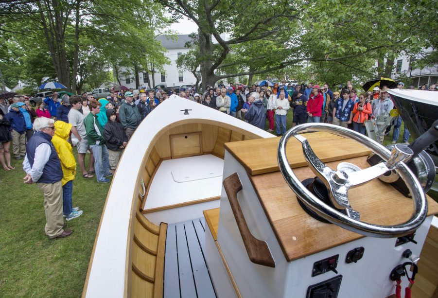 A large crowd gathers to watch students from the Landing School christen newly finished boats in Kennebunkport