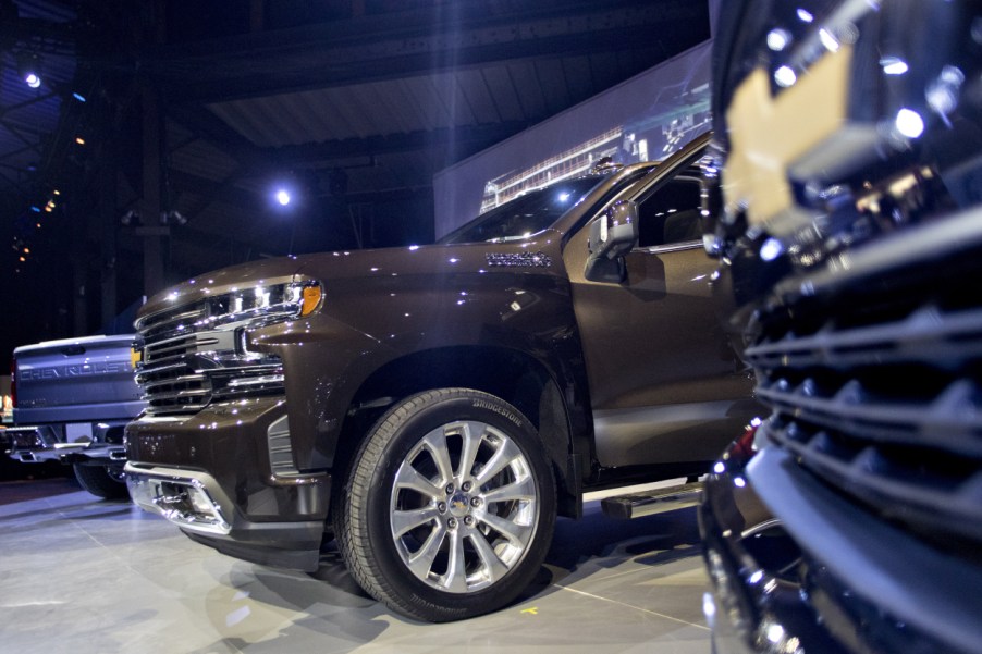 A close up of a few Chevy Silverado trucks on display at an auto show