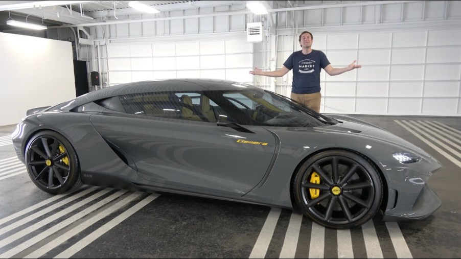 Doug DeMuro with a gray pre-production Koenigsegg Gemera in a hanger