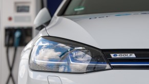 A Volkswagen electric vehicle charges at a charging station