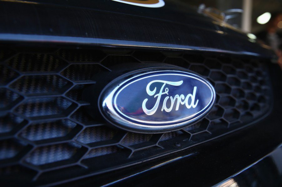 The blue oval Ford logo on the grill of a dark-colored car