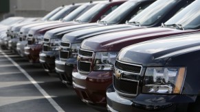 A lineup of GMC Tahoe SUVs on a dealership lot