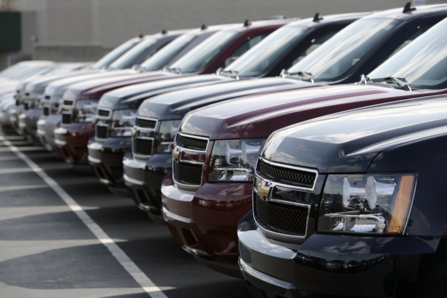 A lineup of GMC Tahoe SUVs on a dealership lot