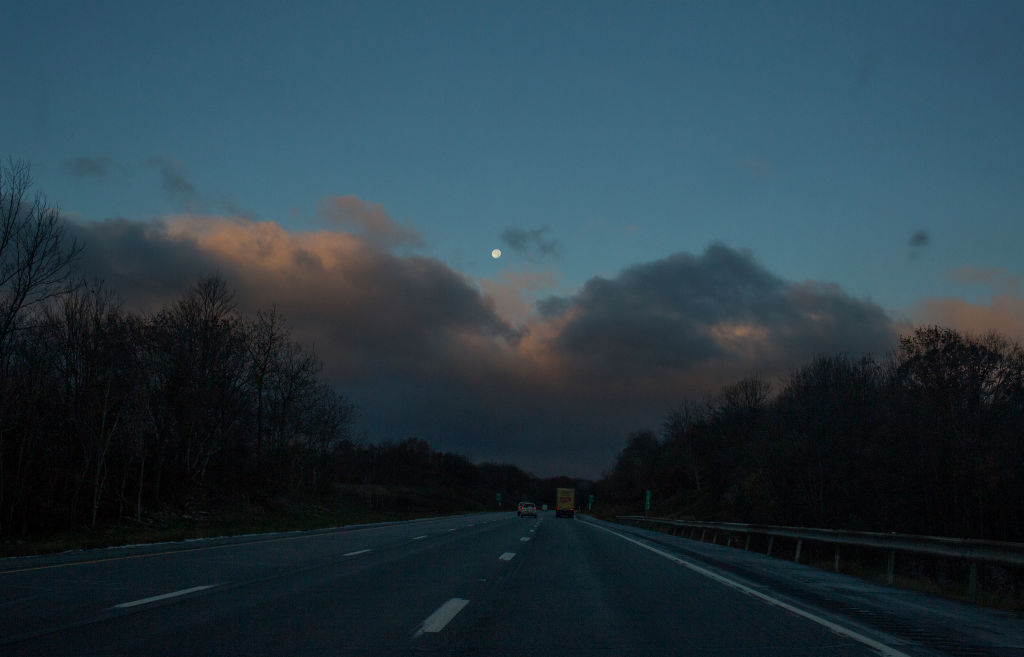 The sun rising over the Pocono Mountains as seen from a car window