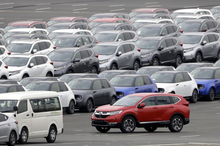 A Honda Motor Co. CR-V sports utility vehicle (SUV) bound for shipment, bottom right, is driven while others sit parked at a port in Yokohama, Kanagawa Prefecture, Japan