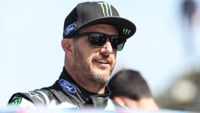 U.S. driver Ken Block standing in the sun wearing a ball cap and sunglasses