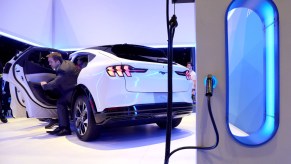 A white Ford Mustang Mach-E plugged in at the Chicago Auto Show