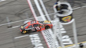 A Nascar race car driven by Martin Truex Jr.goes down the track