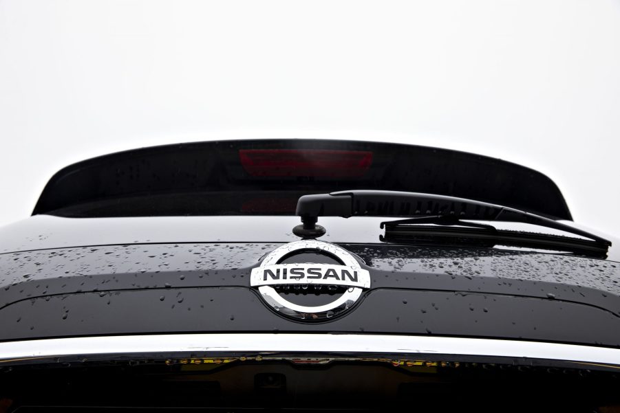 A Nissan logo seen on the back of a Rogue SUV