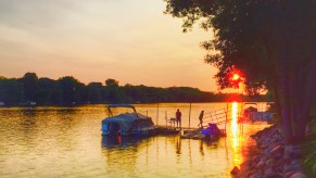 A pontoon boat docked on a lake at sunset