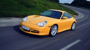 An image of a yellow Porsche 911 GT3 driving on a road.