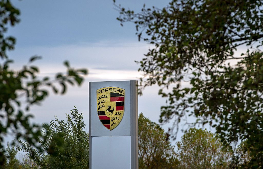 A porsche sign through the trees