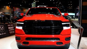 A red Ram 1500 Laramie pickup truck is on display at an auto show