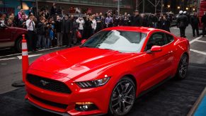 A red Ford Mustang on display at an auto show