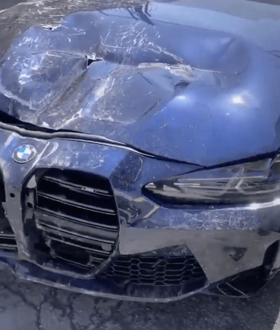 An image of a crashed BMW M3 outdoors.