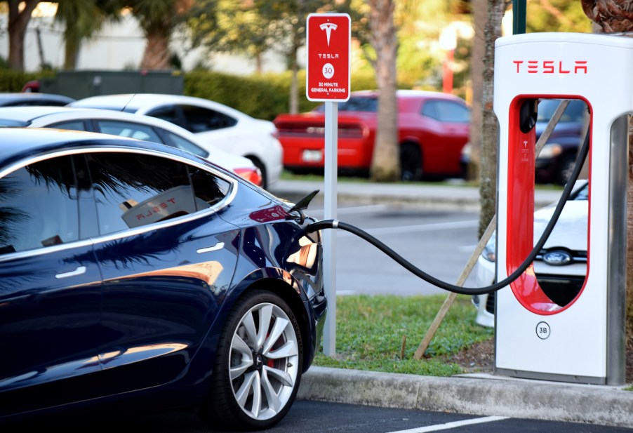 A Tesla plugs in to a Tesla branded electric vehicle charger Electric Vehicle Maintenance