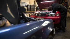 A car mechanic works on his Toyota in a private garage