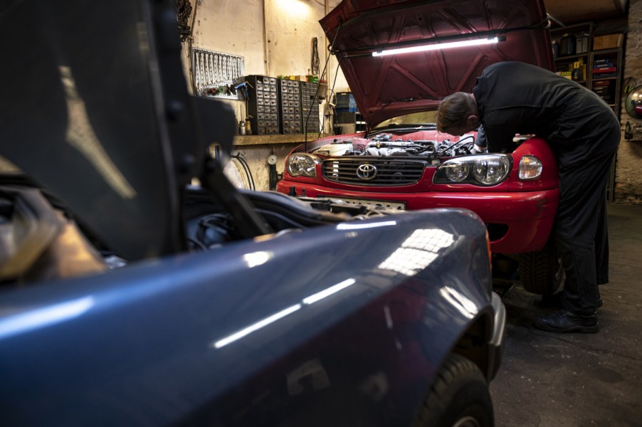 A car mechanic works on his Toyota in a private garage