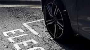 A charging cable is pictured plugged into a Volvo electric vehicle