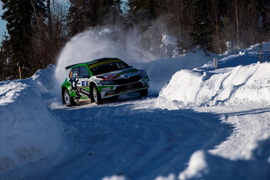 A green-and-white WRC Skoda Fabia Evo drifts through a turn at the snow-covered 2021 Artic Rally Finland