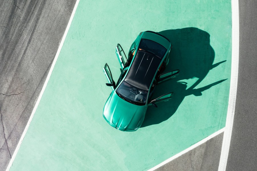 A top view of an emerald green BMW M3 on a green painted pavement