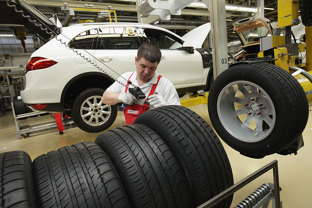 A worker assembles a white Porsche Cayenne