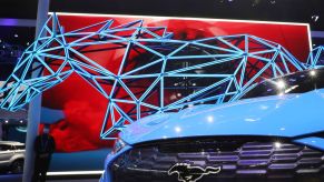 The front end of a blue mustang mach e on display