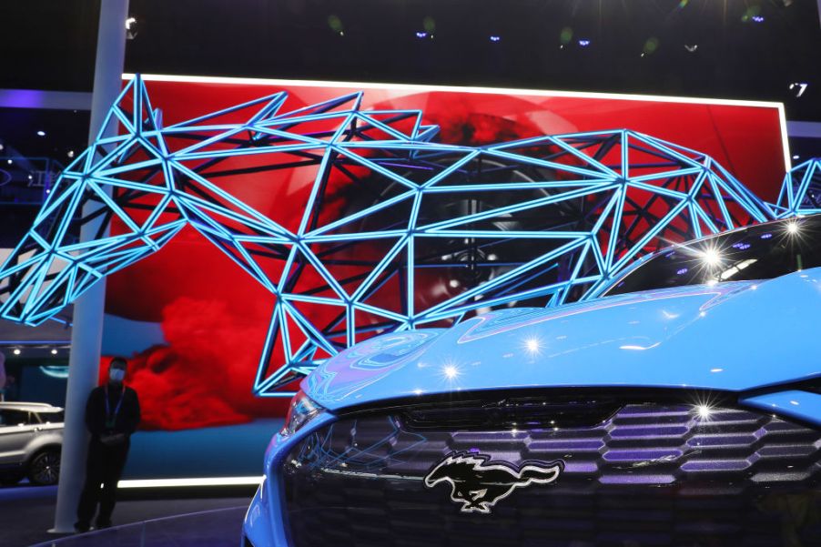 The front end of a blue mustang mach e on display