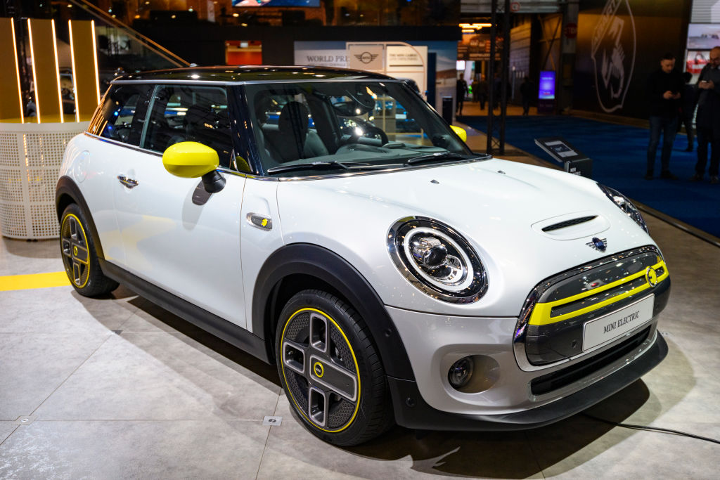 a white electric mini cooper with bright yellow trim 