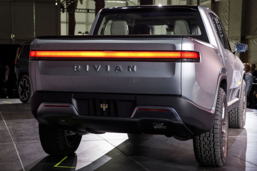 A silver Rivian R1T electric pickup truck, viewed from the rear