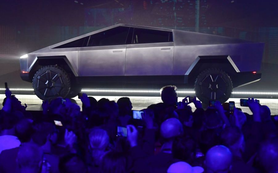 Stainless steel Tesla Cybertruck on display for a large crowd