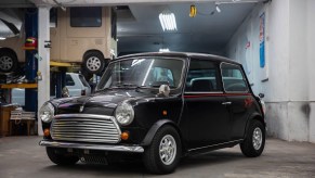 A black 1988 Rover Mini Jet Black Edition in a car workshop garage