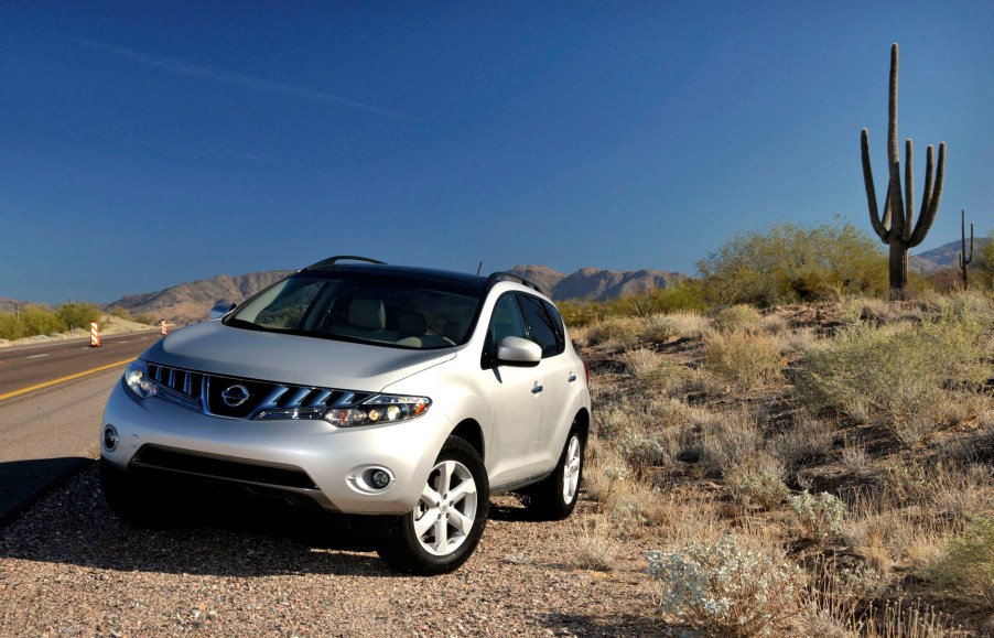 A pearl-white 2009 Nissan Murano midsize SUV parked on the side of the road near a cactus in Sedona, Arizona, during a media preview on December 3, 2007