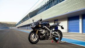 A black-and-silver 2020 Triumph Daytona 765 Moto2 Limited Edition on a rear-wheel stand on a racetrack