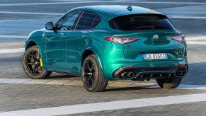 A teal metallic 2021 Alfa Romeo Stelvio Quadrifoglio luxury compact SUV parked on bricks